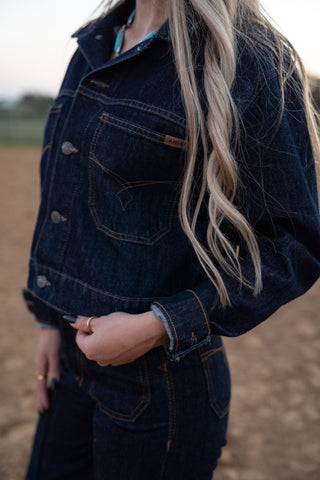 Person wearing a dark denim jacket with a blurred background