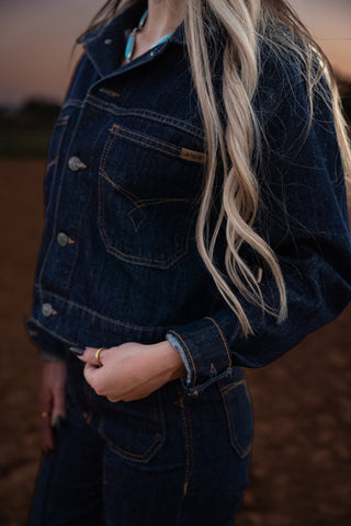 Person wearing a dark denim jacket with a blurred background