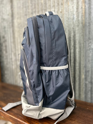 Blue backpack on a wooden surface with a textured wall background