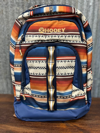 Backpack with tribal pattern and visible brand name on a wooden surface.
