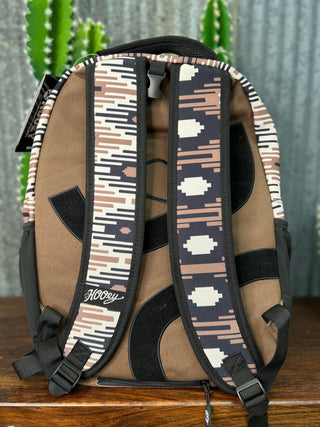 Backpack with patterned straps on a wooden surface with a cactus in the background