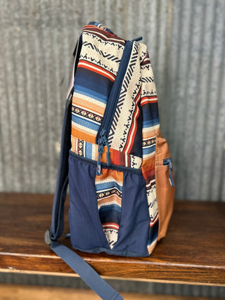 Multicolored patterned backpack on a wooden surface with a rustic background