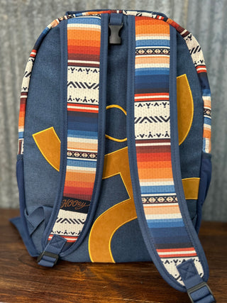 Backpack with colorful patterned straps on a wooden surface