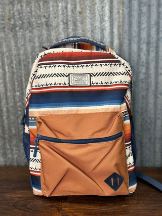 Backpack with a striped pattern on a wooden surface and corrugated metal background