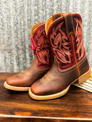 Pair of brown and red cowboy boots with intricate designs on a wooden surface.