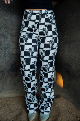 Checkered pants with a black and white pattern worn by a person on a textured surface.