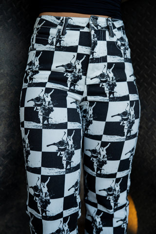 Black and white checkered pants with graphic design on a dark background