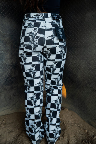 Black and white checkered pants with abstract patterns worn by a person against a dark background.
