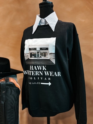 Black sweatshirt with graphic design on a mannequin against a brown background