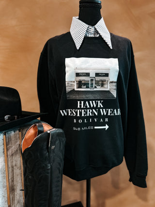 Black sweatshirt with 'Hawk Western Wear Bolivar' print on a mannequin against a brown background.