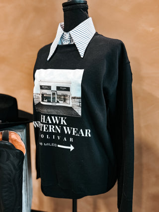 Black sweatshirt with graphic design on a mannequin against a brown background