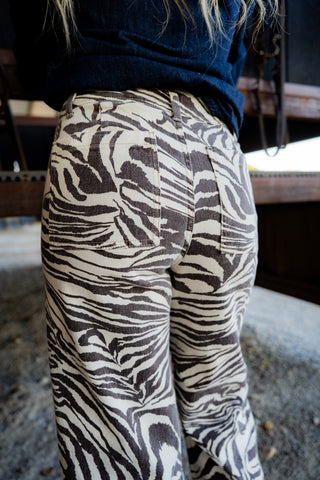 Person wearing zebra-patterned pants with a blurred background