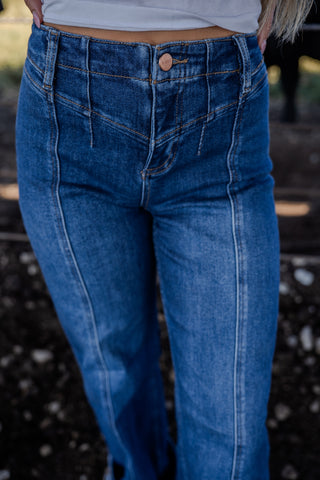 Blue jeans worn by a person with a blurred background
