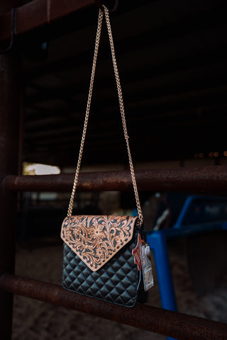 Handbag with floral pattern and chain strap on a dark background
