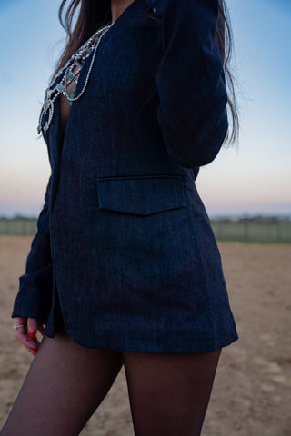 Person wearing a dark blue blazer with embellishments outdoors