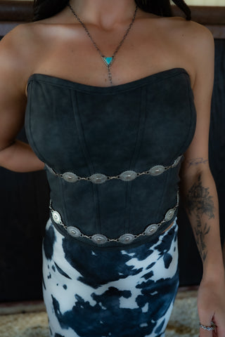 Person wearing a black strapless top with silver embellishments and a white and blue patterned skirt.