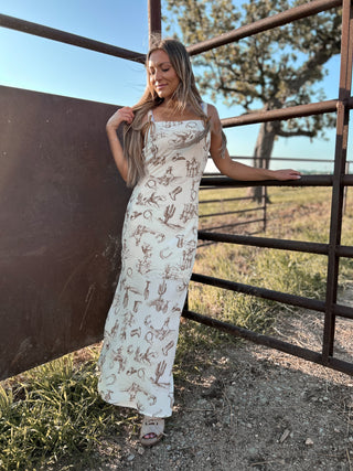Woman in a patterned dress standing near a metal gate in an outdoor setting
