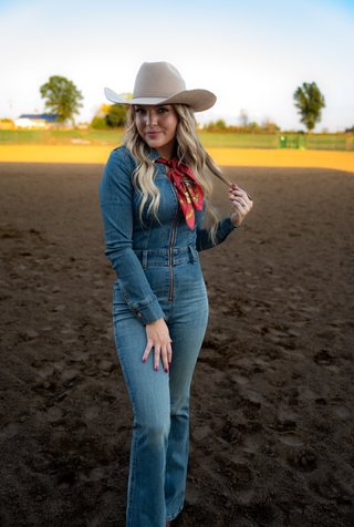 Woman in a denim outfit and cowboy hat standing in an outdoor setting