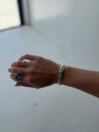 Hand with rings and bracelets on a neutral background