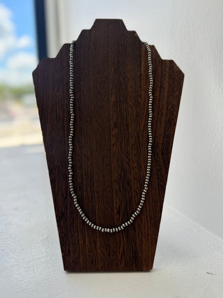 Necklace on a wooden display stand with a blurred background