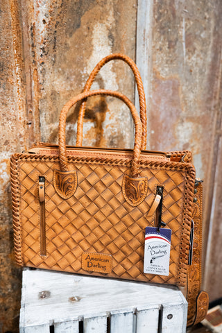 Brown woven handbag with a tag on a rustic wooden surface