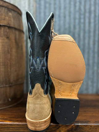 Pair of cowboy boots with a focus on the sole and stitching detail, set against a rustic background.