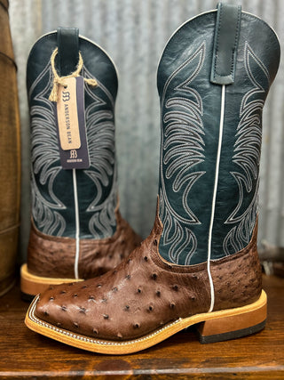 Pair of brown cowboy boots with detailed design on a wooden surface