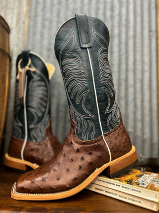 Brown cowboy boot with detailed design on a wooden surface
