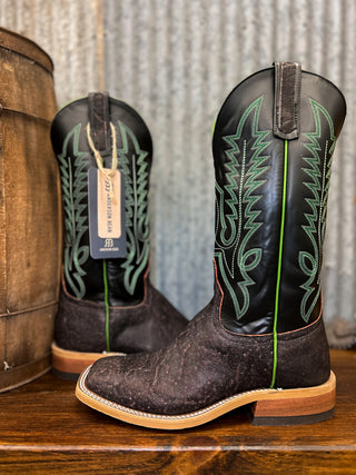 Pair of cowboy boots with intricate designs on a wooden surface.