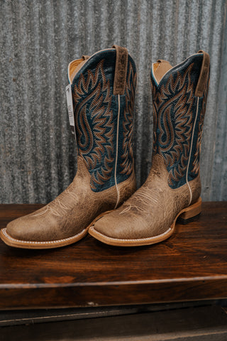 Pair of tan cowboy boots with intricate blue and brown designs on a wooden surface.