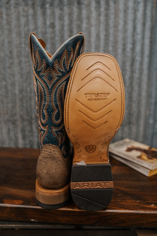 Close-up of a brown cowboy boot with intricate design on a wooden surface.