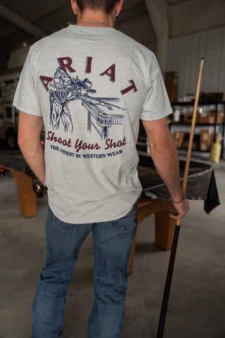 Person wearing a t-shirt with a graphic design and text, standing in an indoor setting.