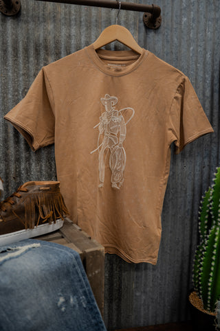 Brown t-shirt with a graphic design on a hanger against a rustic metal wall.