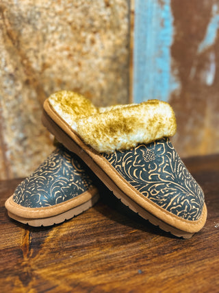 Pair of slippers with gold interior and patterned exterior on a wooden surface.