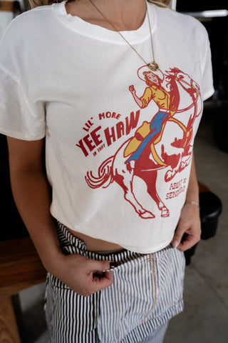 Person wearing a white t-shirt with a graphic design and text.