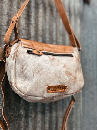 Vintage-style handbag with brown leather accents on a textured gray background