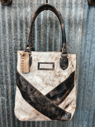 Handbag with brown and beige pattern against a corrugated metal background