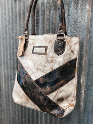 Vintage-style handbag with a chevron pattern against a textured metal background