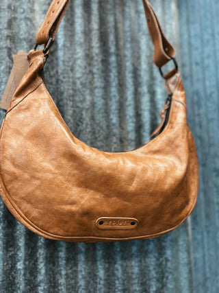 Brown leather handbag with visible brand name on a textured blue background