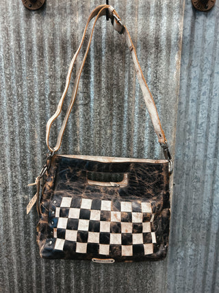 Vintage-style handbag with checkered pattern on a corrugated metal background