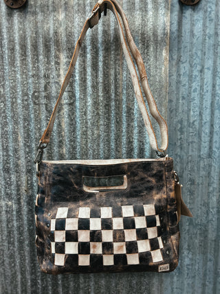 Handbag with checkered pattern on a textured metal surface