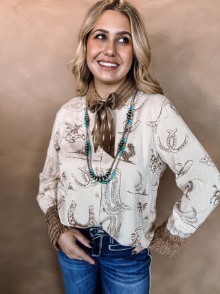 Woman wearing a patterned blouse with decorative elements against a beige background