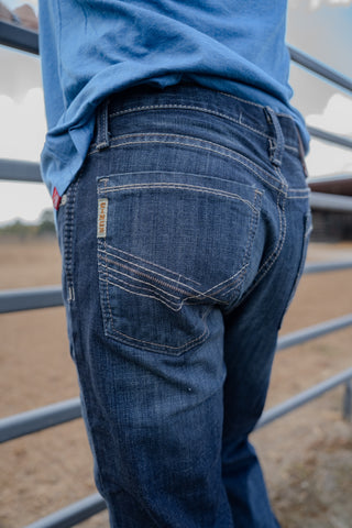 Person wearing blue jeans and a blue shirt with a blurred background