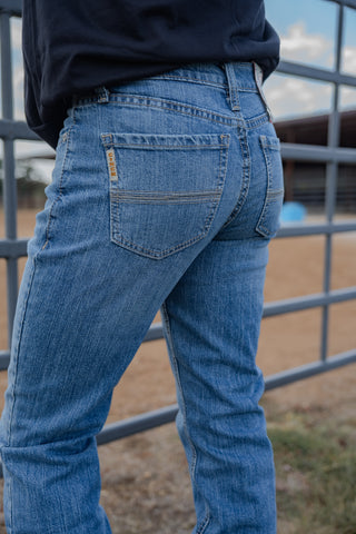 Person wearing blue jeans with a blurred background