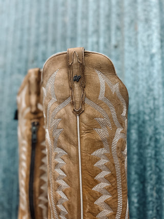 Brown leather bag with intricate patterns on a textured gray background