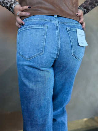 Blue jeans with a tag on a neutral background