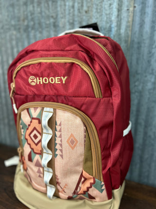 Red backpack with a patterned compartment and 'HOOey' branding on a textured surface.