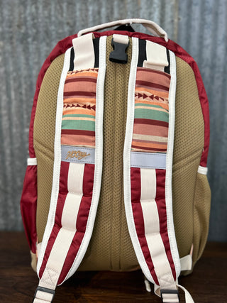 Backpack with patterned straps on a wooden surface and gray background