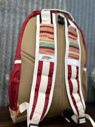 Backpack with striped straps on a wooden surface