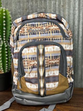 Backpack with tribal pattern on a wooden surface with a cactus in the background